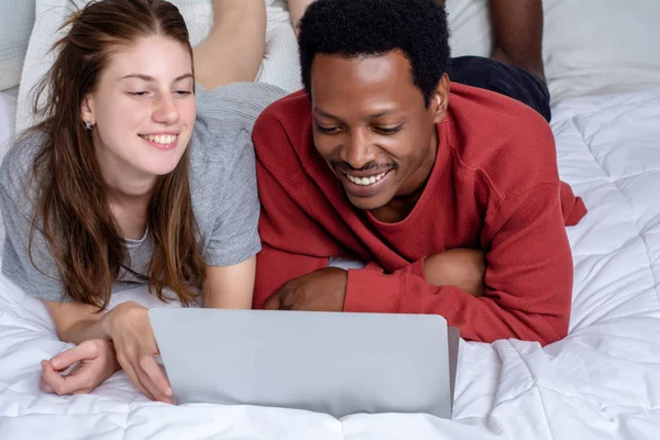 年轻夫妇在家里的床上使用笔记本电脑. — 图库照片