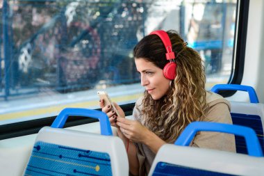 Kadın akıllı telefon kullanarak tren ile seyahat.