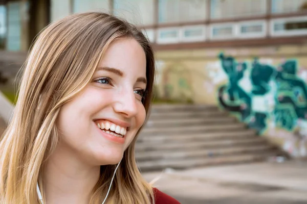 Mladá blondýnka naslouchající hudbě s sluchátkami — Stock fotografie