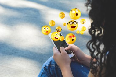 Emojis gönderme smartphone kullanan kadın.