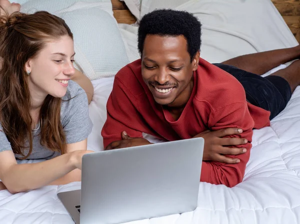 年轻夫妇在家里的床上使用笔记本电脑. — 图库照片