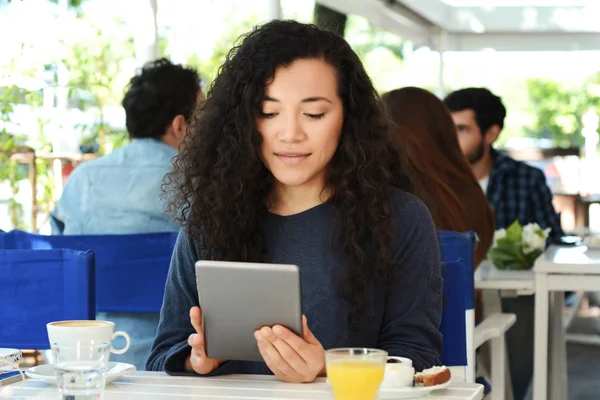 Mujer joven con tableta en la cafetería . —  Fotos de Stock