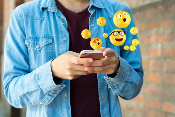 Homem usando smartphone enviando emojis — Fotografia de Stock