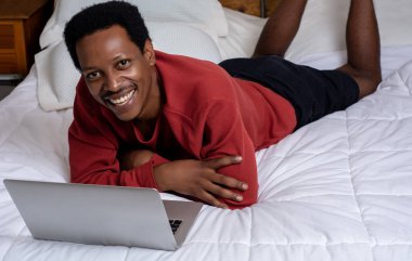 Yatakta onun laptop kullanan genç adam