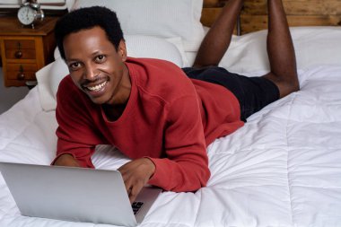 Yatakta onun laptop kullanan genç adam