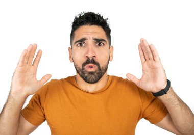 Stüdyoda beyaz arka plana karşı endişeli bir genç adam portresi.