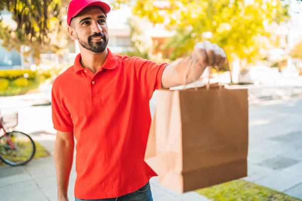 Paket taşıyan bir teslimatçının portresi müşterisine teslimat yaparken. Teslimat ve nakliye konsepti.