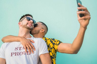 Mutlu eşcinsel çiftin portresi. Birlikte zaman geçirip cep telefonuyla selfie çekiyorlar. Lgbt ve Aşk Konsepti.