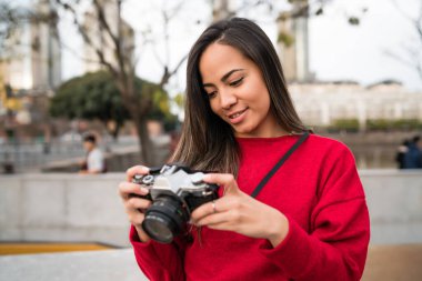 Açık havada profesyonel dijital kamera kullanan genç fotoğrafçı kadının portresi. Fotoğraf konsepti
