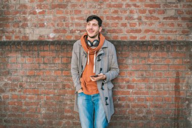 Sokakta cep telefonunu kullanan genç Latin bir adamın portresi. İletişim konsepti.