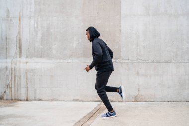 Gri arka planda koşan bir fitness oyuncusunun portresi. Spor ve sağlıklı yaşam tarzı.