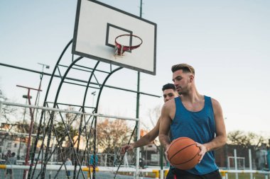 Genç basketbolcular dışarıda teke tek oynuyor. Spor ve basketbol konsepti.