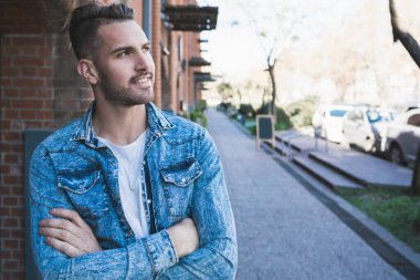 Sokaklarda günlük giysiler giyen yakışıklı bir gencin portresi. Şehir konsepti.