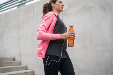 Dışarıda merdivenlerde koşan bir kadının portresi. Fitness, spor ve sağlıklı yaşam tarzı kavramları.