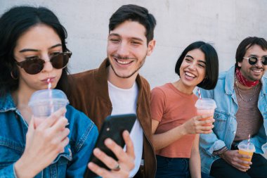 Birlikte eğlenen ve taze meyve suyu içerken eğlenen bir grup arkadaşın portresi. Yaşam tarzı ve arkadaşlık kavramı.