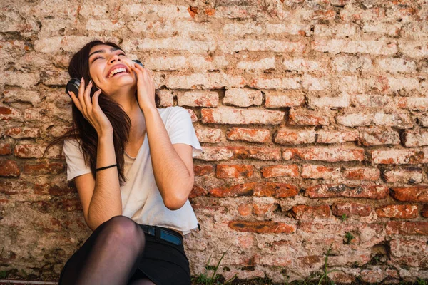 Genç Latin Kadın Portresi Rahatla Tuğla Duvara Karşı Kulaklıkla Müzik — Stok fotoğraf