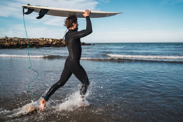 Der Junge Surfer Steigt Mit Seinem Surfbrett Einem Schwarzen Surfanzug — Stockfoto