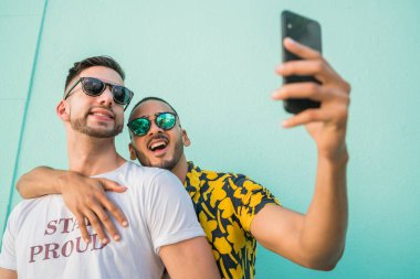 Mutlu eşcinsel çiftin portresi. Birlikte zaman geçirip cep telefonuyla selfie çekiyorlar. Lgbt ve Aşk Konsepti.