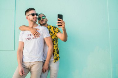 Mutlu eşcinsel çiftin portresi. Birlikte zaman geçirip cep telefonuyla selfie çekiyorlar. Lgbt ve Aşk Konsepti.