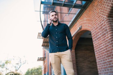 Sokakta telefonda konuşan yakışıklı bir gencin portresi. İletişim konsepti.