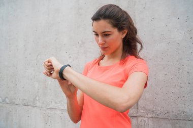 Akıllı saatini kontrol eden bir fitness kadınının portresi. Spor ve sağlıklı yaşam tarzı kavramı.