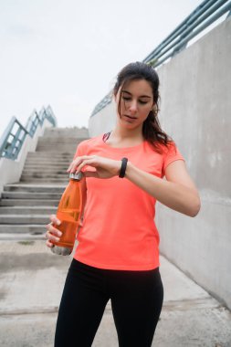 Akıllı saatini kontrol eden bir fitness kadınının portresi. Spor ve sağlıklı yaşam tarzı kavramı.