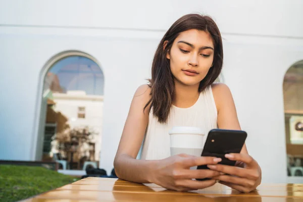 Retrato Una Joven Latina Usando Teléfono Móvil Mientras Está Sentada —  Fotos de Stock