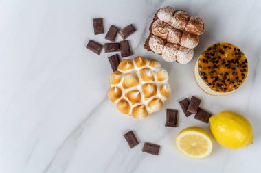 Lezzetli mini çikolataya, limonlu turtaya ve tutkulu meyveli keke yakın plan. Pişirme kavramı.