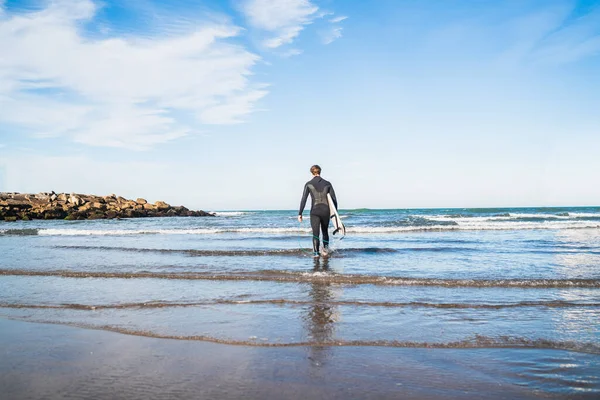 Der Junge Surfer Steigt Mit Seinem Surfbrett Einem Schwarzen Surfanzug — Stockfoto