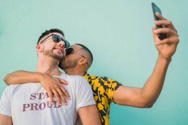 Mutlu eşcinsel çiftin portresi. Birlikte zaman geçirip cep telefonuyla selfie çekiyorlar. Lgbt ve Aşk Konsepti.