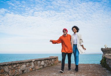 İki genç arkadaşın portresi. Birlikte güzel vakit geçiriyorlar. Sahil şeridinde yürüyüp eğleniyorlar..