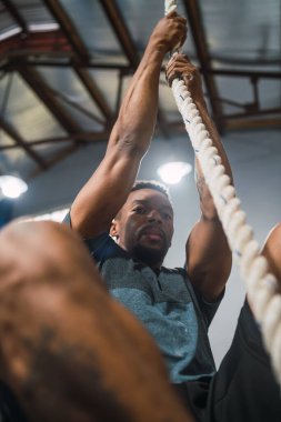 Spor salonunda tırmanma egzersizi yapan bir sporcunun portresi. Crossfit, spor ve sağlıklı yaşam tarzı konsepti.