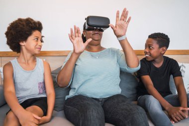 Evde VR gözlükleriyle oynayan Afrikalı Amerikalı büyükanne ve torunların portresi. Aile ve teknoloji kavramı.