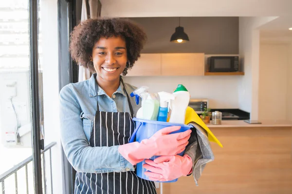 自宅に掃除用品の入ったバケツを持った若いアフロ女性の肖像画 清掃のコンセプト — ストック写真