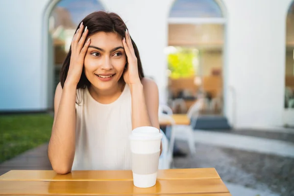 描述年轻的拉丁女子在咖啡店外面喝着一杯咖啡的形象 生活方式概念 — 图库照片