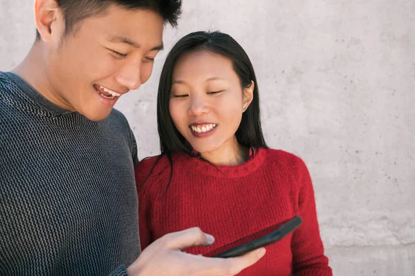 스러운 아시아인 부부가 시간을 보내면서 핸드폰을 사랑과 — 스톡 사진