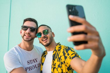 Mutlu eşcinsel çiftin portresi. Birlikte zaman geçirip cep telefonuyla selfie çekiyorlar. Lgbt ve Aşk Konsepti.
