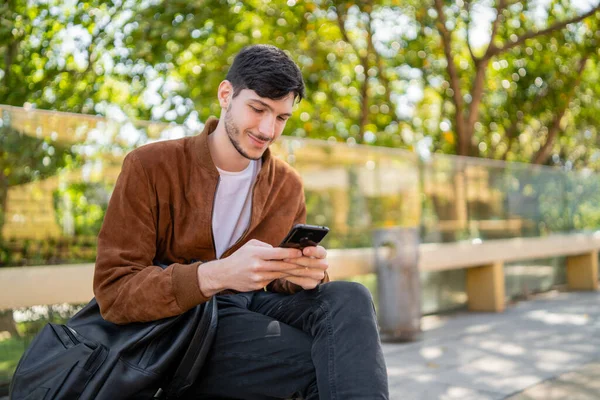 Egy Fiatal Jóképű Férfi Portréja Amint Mobilját Használja Miközben Szabadban — Stock Fotó