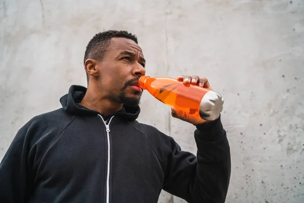 Porträtt Atletisk Man Dricka Något Efter Träning Mot Grå Bakgrund — Stockfoto