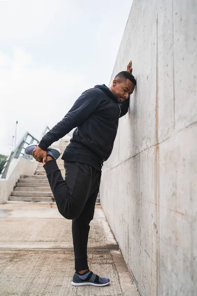 Açık havada egzersiz yapmadan önce bacaklarını esneten bir sporcunun portresi. Spor ve sağlıklı yaşam tarzı.