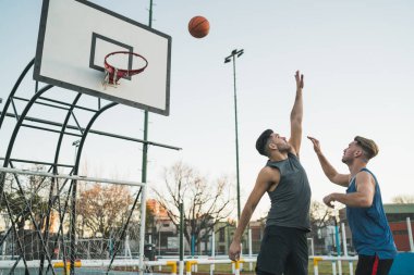 Genç basketbolcular dışarıda teke tek oynuyor. Spor ve basketbol konsepti.