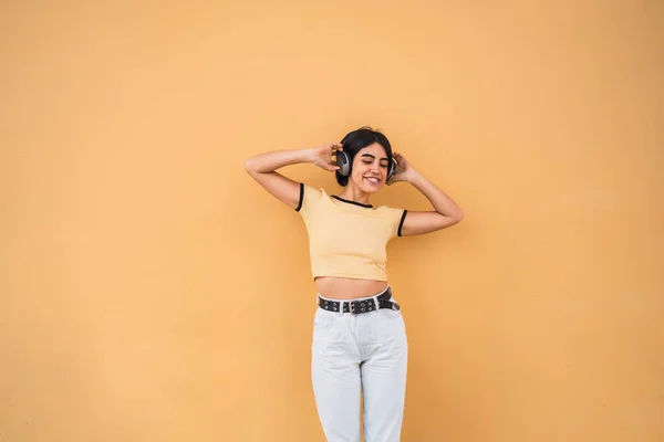 Porträtt Ung Latinamerikansk Kvinna Lyssnar Musik Med Hörlurar Mot Gul — Stockfoto