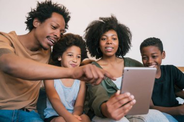 Afro-Amerikan aile portresi evde dijital tabletle selfie çekiyor. Aile ve yaşam tarzı kavramı.