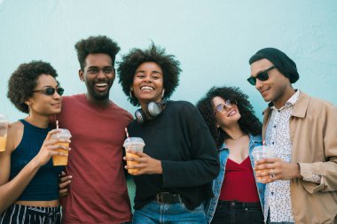 Afro arkadaşların portresi. Birlikte eğleniyorlar ve taze meyve suyu içerken eğleniyorlar.. 
