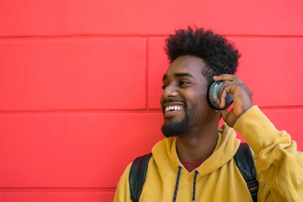 Retrato Joven Afro Escuchando Música Con Auriculares Sobre Fondo Rojo — Foto de Stock