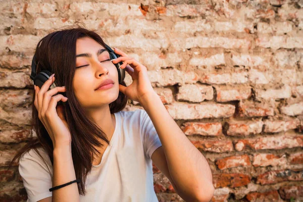 Portrét Mladé Latinské Ženy Relaxovat Poslouchat Hudbu Sluchátky Cihlové Zdi — Stock fotografie