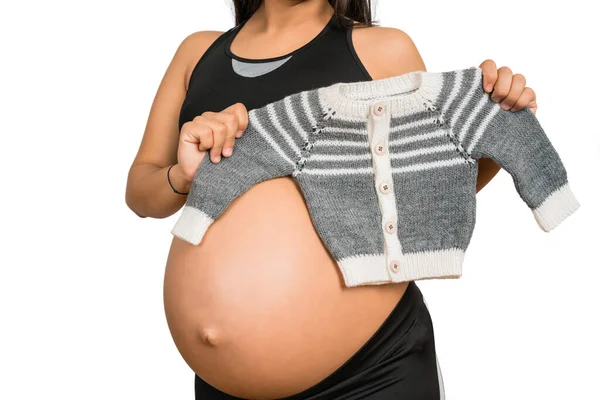 Close Mulher Grávida Segurando Roupas Bebê Contra Fundo Branco Gravidez — Fotografia de Stock