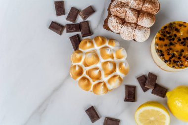 Lezzetli mini çikolataya, limonlu turtaya ve tutkulu meyveli keke yakın plan. Pişirme kavramı.