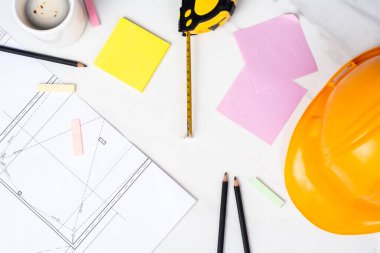 Planlara yakın çekim, mezura ve sarı miğfer. Mühendis kavramı