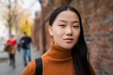 Sokakta duran güzel Asyalı kadının portresi. Şehir konsepti.